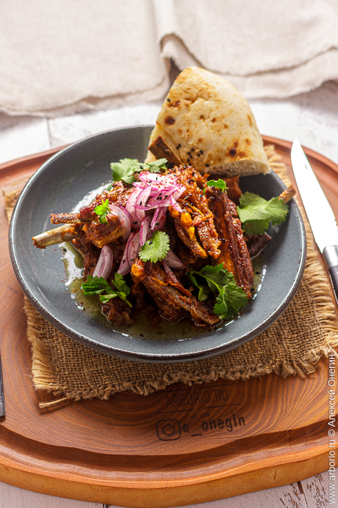 Тушёные бараньи рёбра с луком на плите в сотейнике